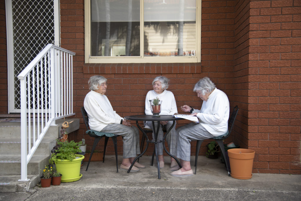 3 images combined to create this photo that looks like 3 ladies all looking the same sitting around a table
