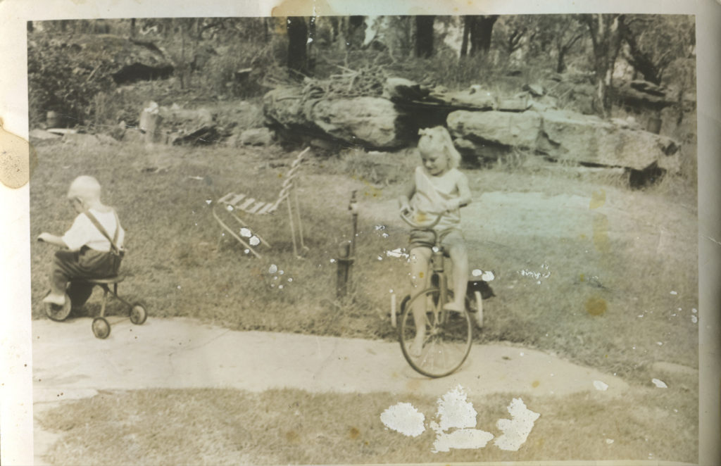 Girl and boy on tricycles in the 60's