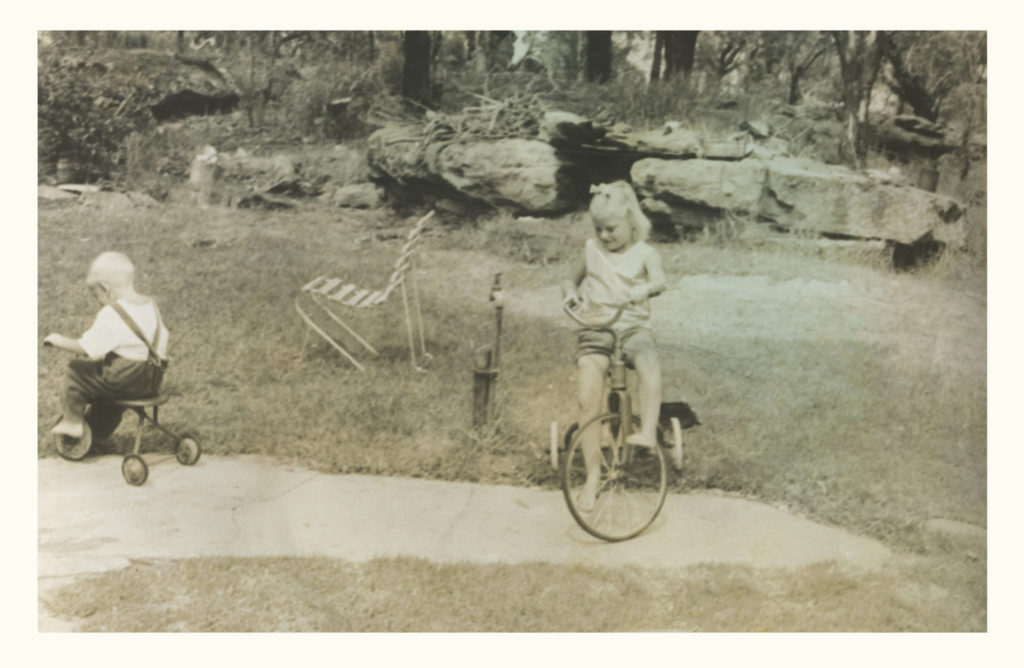 Girl and boy on tricycles in the 60's